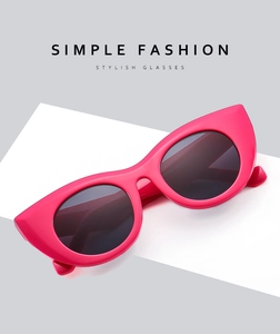 Macro detail of glossy pink cat-eye sunglasses with gradient dark grey lenses