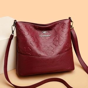 Sac seau en cuir bordeaux profond avec motifs trèfle en relief et logo en métal