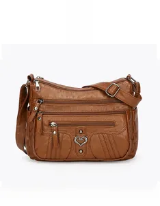 Front view of brown soft leather crossbody bag with multiple zippers and heart details