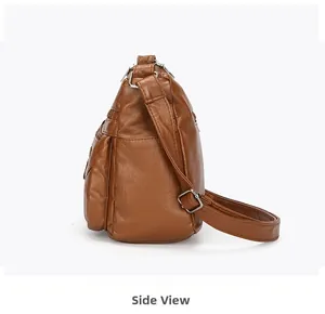 Side view of brown leather crossbody bag showing multiple layers and silver buckle