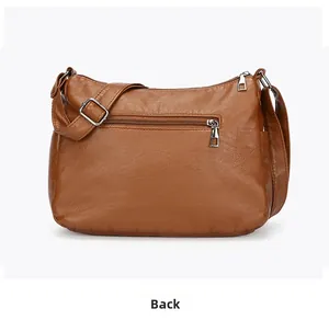 Rear view of brown leather crossbody bag featuring a zippered pocket and adjustable strap