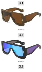 Detail view of futuristic oversized sunglasses with gradient lenses and gold rivets