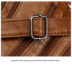 Detail of brown leather texture with adjustable metal buckle and multi-zipper pocket design