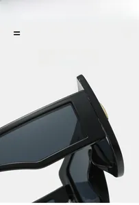 Detail of high-gloss black square sunglasses featuring thick temples and gold metal accents
