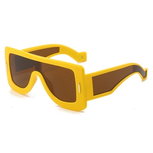 Futuristic yellow geometric oversized sunglasses with brown lenses and silver accents