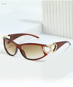 Detail of double heart metal hinge on brown Y2K sunglasses with gradient lenses