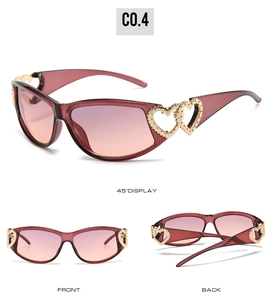 Detail of red Y2K sunglasses featuring golden double-heart hinges and gradient lenses
