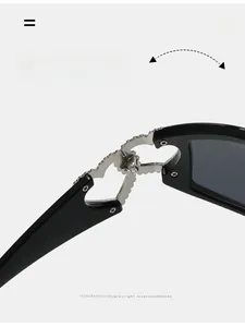 Macro detail of silver heart-shaped metal hinge on black Y2K fashion sunglasses