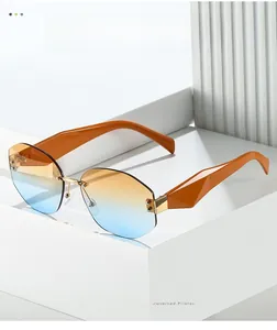 Detail of rimless sunglasses with orange-blue gradient lenses and geometric carved temples