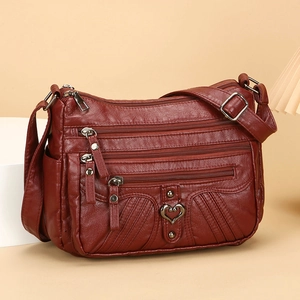 Deep red soft leather crossbody bag with multi-pocket design and heart metal accents