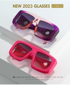 Close-up of oversized purple gradient and pink computer safety glasses on white stands
