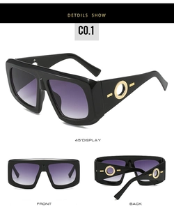 Detail view of large black frame sunglasses with purple gradient lenses and gold accents
