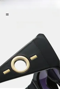 Detail view of high-gloss black sunglass temples with golden hollow circular metal ornaments