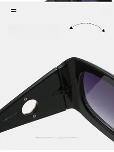Detail view of durable metal hinge and printed size specs on black oversized sunglasses