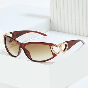 Y2K fashion double heart sunglasses with amber PC frame and gradient lenses on a minimalist stand