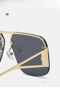 Detail of pilot sunglasses showing golden metal hinges and hollow triangle design
