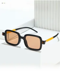 Detail of square sunglasses featuring black and yellow dual-tone temples with spherical hinges