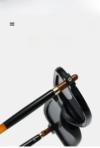 Detail of vintage square sunglasses with black glossy frame and gold metal hinge accents