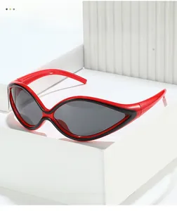 Futuristic red cat-eye sunglasses with black trim resting on a minimalist white block