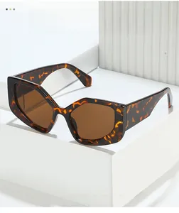 Detail of tortoise shell hexagon sunglasses with brown lenses on a white geometric stand