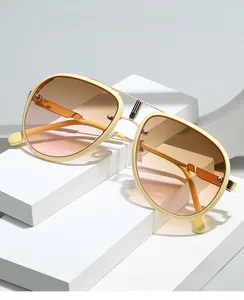 Détail de lunettes aviateur vintage avec monture beige et verres dégradés orange