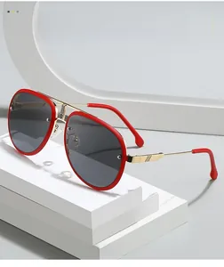 Détail de lunettes aviateur avec bordure en résine rouge et pont en métal doré sur socle