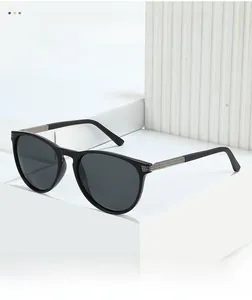 Close-up of black sunglasses featuring textured silver metal hinges and dark grey lenses