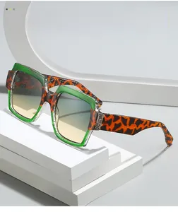 Detail of square sunglasses featuring green transparent and leopard print contrast frames