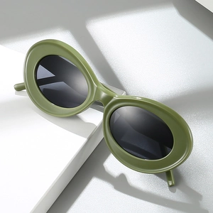 Modern oval cat eye sunglasses in olive green frame with dark lenses on display