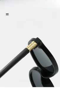 Détail macro de lunettes noires avec un accent métallique doré en pyramide sur la branche