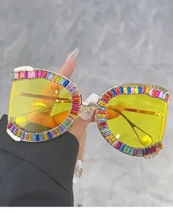 Macro detail of oversized square sunglasses with gold frame and rainbow crystal embellishments