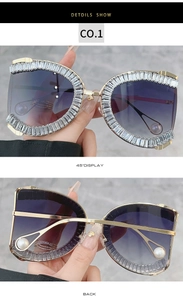 Detail of gold metal cat-eye sunglasses with purple gradient lenses and pearl temples