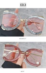 Detail of oversized gold metal sunglasses with crystal embellishments and pearl tips