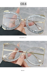 Detail view showing oversized gold frames with crystal inlay and pearl drop temple tips