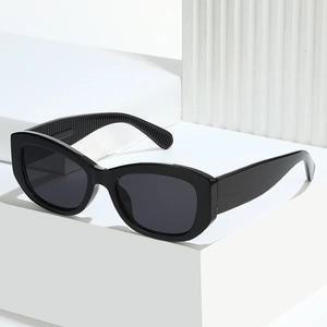 Lunettes de soleil œil de chat noires avec monture large sur fond blanc minimaliste