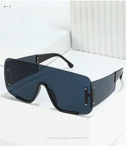 Detail of oversized shield sunglasses with dark grey lenses and silver rivets