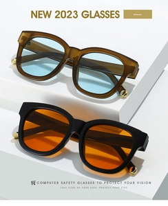 Detail of vintage oval sunglasses with gold hinge accents on a white geometric stand