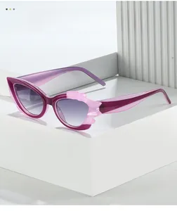 Detail of purple cat-eye sunglasses with pink wavy accents and blue gradient lenses