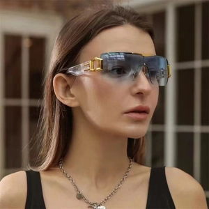 Close-up of oversized Y2K sunglasses with gradient blue lenses and gold metal accents