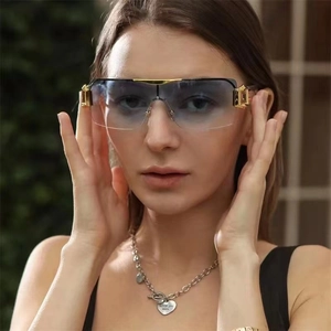 Close-up of stylish Y2K oversized blue gradient sunglasses with luxury gold metal hardware