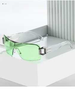 Detail of light green rimless Y2K sunglasses with silver metal accent on acrylic frame