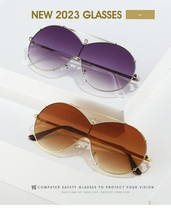 Detail of oversized shield sunglasses with purple and brown gradient lenses on white blocks