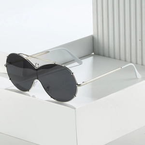 Oversized silver metal frame shield sunglasses with dark lenses on white minimalist steps