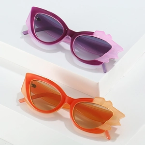 Stylish flame shaped cat eye sunglasses in purple and orange gradient on a white stand