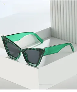 Close-up of green cat eye sunglasses with striped texture and dark grey lenses