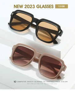 Detail view of square oversized sunglasses with silver arrow rivets on white steps