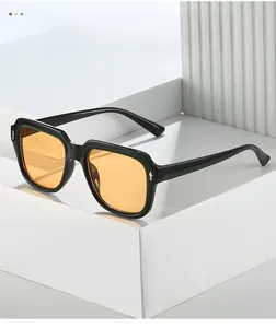 Detail of vintage square sunglasses with silver arrow metal studs and orange lenses