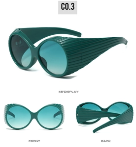 Detail view of oval sunglasses with unique horizontal ribbed texture and gradient lenses