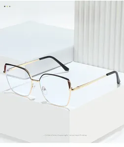 Close-up of golden cat-eye metal glasses frame on white geometric display blocks