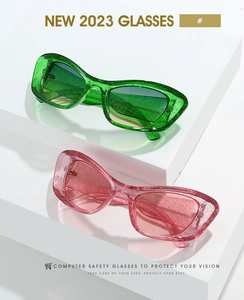 Detail of glitter cat-eye sunglasses frames in green and pink on geometric stands